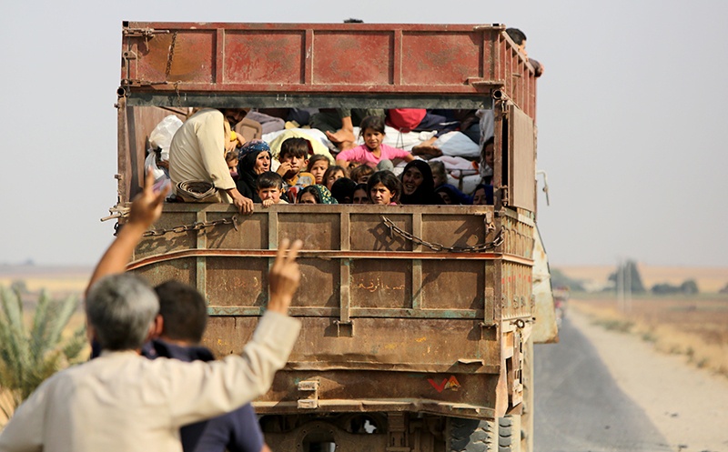 Kurdish Syrian civilians flee the town of Kobani on the Turkish border on October 16, 2019 as Turkey and its allies continue their assault on Kurdish-held border towns in northeastern Syria. - Turkey rebuffed international pressure to curb its military offensive against Kurdish militants in Syria today as US President Donald Trump dispatched his deputy Mike Pence to Ankara to demand a ceasefire. (Photo by Bakr ALKASEM / AFP)