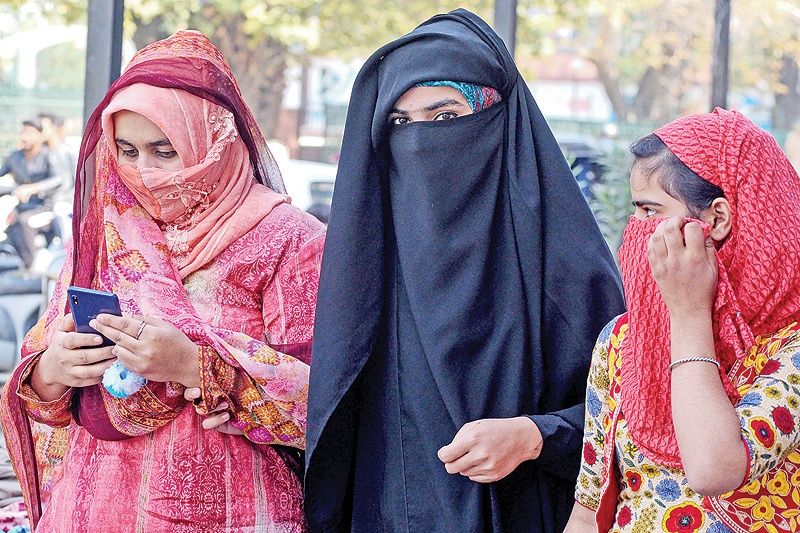 SRINAGAR: Women look on as they use mobiles phones in Srinagar on October 14, 2019, following Indian government’s decision to restore mobile phones network in Indian-administered Kashmir. — AFP