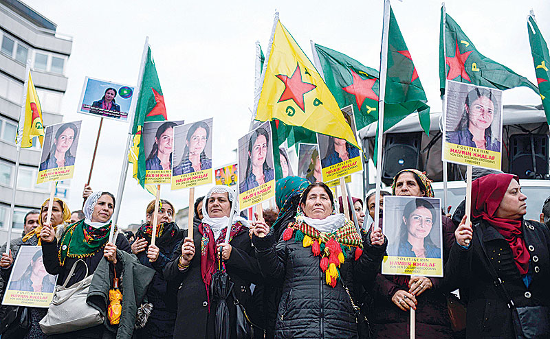 COLOGNE: Kurdish protesters wave their national flags and hold photos of former Kurdish political leader Hevrin Khalaf, during a pro-Kurdish demonstration in Cologne, western Germany. —AFP