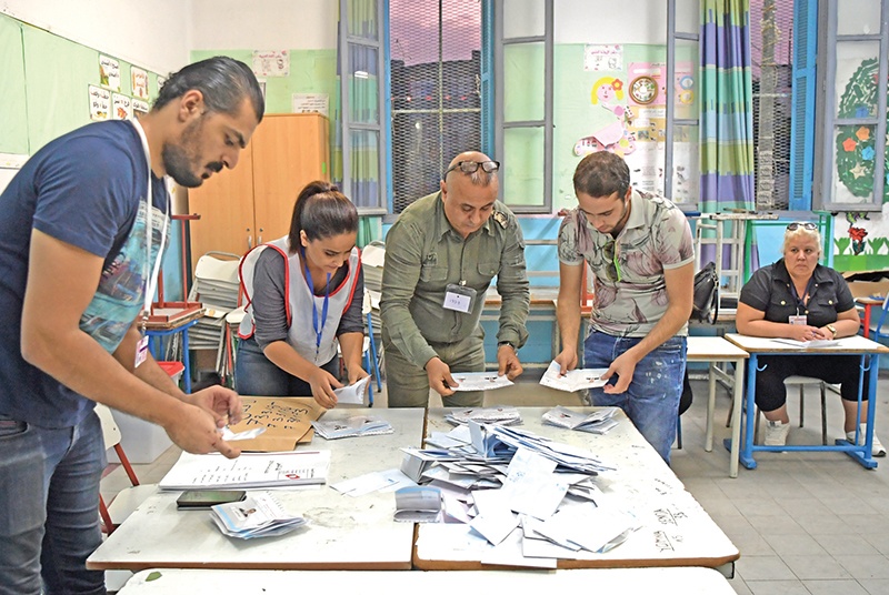 Tunisian electoral officials count the ballots at a polling station in the capital Tunis, on October 13, 2019. - Tunisians voted in a presidential runoff pitting a conservative academic against a media magnate fresh out of jail, reflecting the country's shifting post-revolution political landscape. (Photo by Fethi Belaid / AFP)