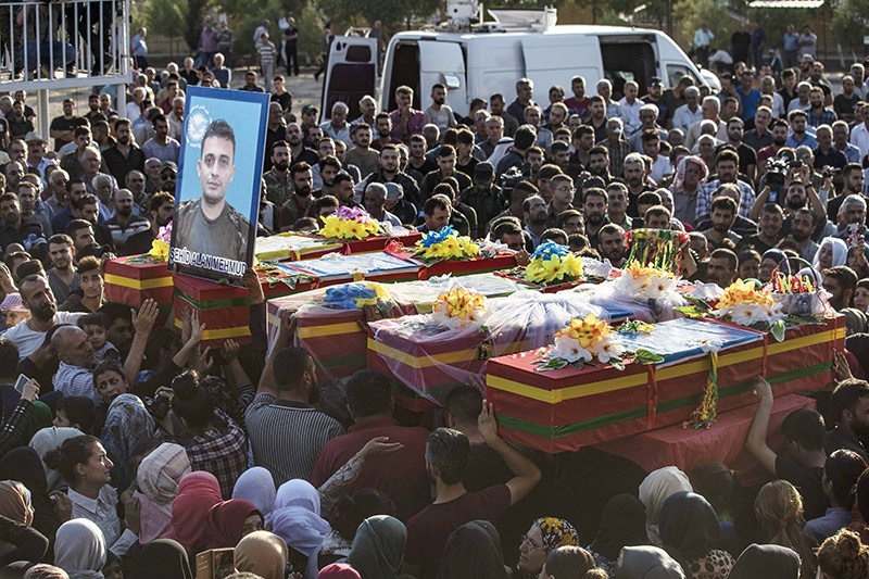 Mourners attend the funeral of five Syrian Democratic Forces' fighters killed in battles against Turkey-led forces in the flashpoint town of Ras al-Ain along the border, on October 14, 2019 in the Syrian Kurdish town of Qamishli. - The Syrian regime sent troops towards the Turkish border today to contain Ankara's deadly offensive against the Kurds, stepping in for US forces due to begin a controversial withdrawal. (Photo by Delil SOULEIMAN / AFP)