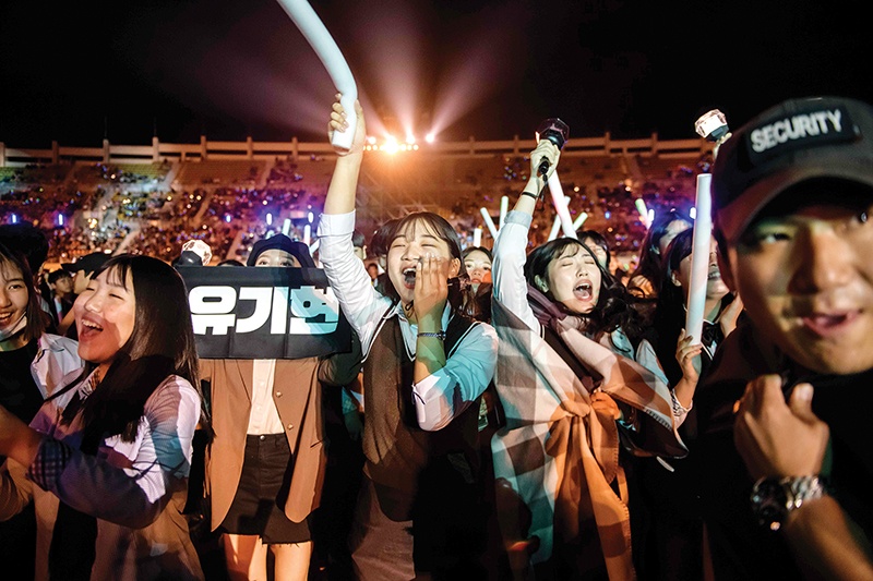 In a photo taken on October 11, 2019, audience members cheer for a professional K-pop band performing between rounds of amateurs, at the 'K-pop World Festival' in Changwon. - At the grandly titled and government-funded Changwon K-pop World Festival contestants from around the globe perform imitation dances or sing cover versions of the genre's biggest hits -- with thousands of fans cheering them on. (Photo by Ed JONES / AFP) / TO GO WITH SKorea-entertainment-music-diplomacy,FOCUS by Claire Lee