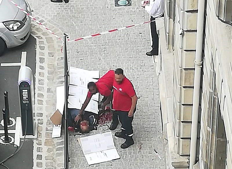 PARIS: Two emergency members stand by the body of Mickael Harpon, 45-year-old computer expert, shot dead by a policeman after he stabbed four colleagues to death in a frenzied attack at Paris police headquarters. —AFP
