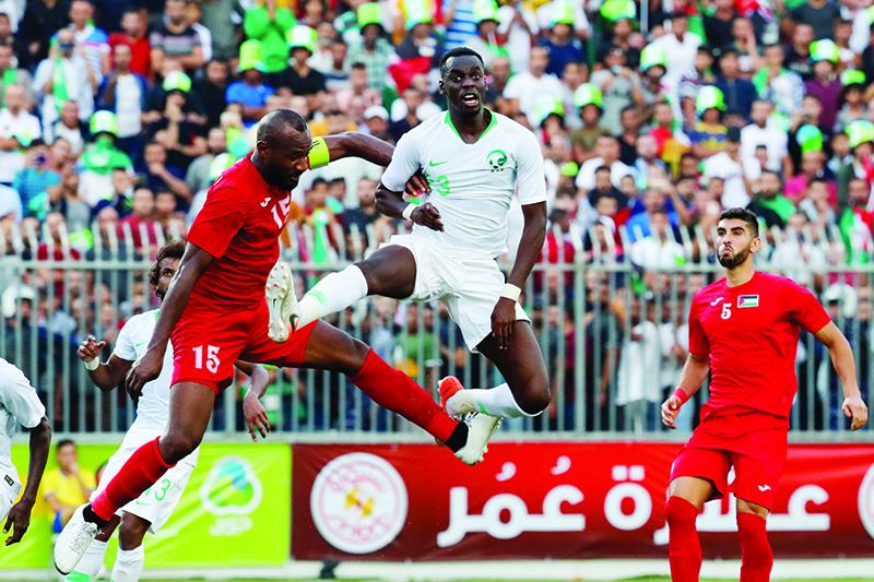 Saudi's defender Ziyad Al-Sahafi vies for the ball with Palestine's defender Abdelatif Bahdari during the World Cup 2022 Asian qualifying match between Palestine and Saudi Arabia in the town of al-Ram in the Israeli occupied West Bank on October 15, 2019. - The game would mark a change in policy for Saudi Arabia, which has previously played matches against Palestine in third countries. Arab clubs and national teams have historically refused to play in the West Bank, where the Palestinian national team plays, as it required them to apply for Israeli entry permits. (Photo by Ahmad GHARABLI / AFP)