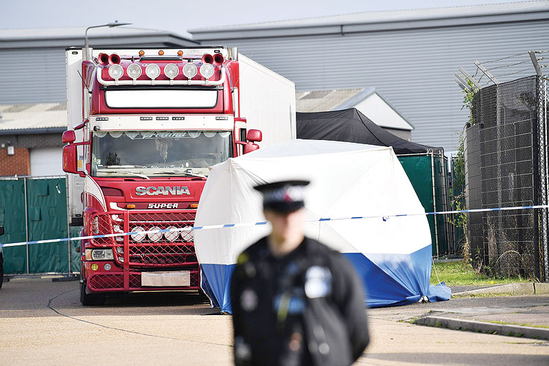 GRAYS, United Kingdom: A police officer secures the cordon at the scene where a lorry containing 39 dead bodies was discovered at Waterglade Industrial Park yesterday. - AFP 