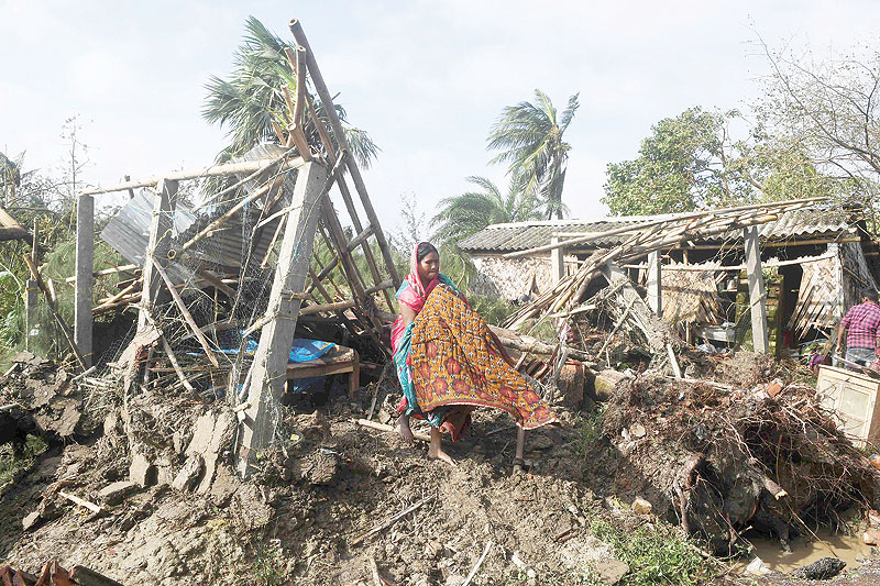 NAMKHANA, India: A woman cleans her house damaged by Cyclone Bulbul in Bakkhali yesterday. — AFP