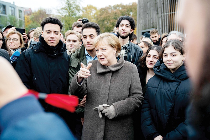 German Chancellor Angela Merkel (C) talks with young people during the central commemoration ceremony for the 30th anniversary of the fall of the Berlin Wall, on November 9, 2019 at the Berlin Wall Memorial at Bernauer Strasse in Berlin. - Germany celebrates 30 years since the fall of the Berlin Wall ushered in the end of communism and national reunification, as the Western alliance that secured those achievements is increasingly called into question. (Photo by Kay Nietfeld / DPA / AFP) / Germany OUT