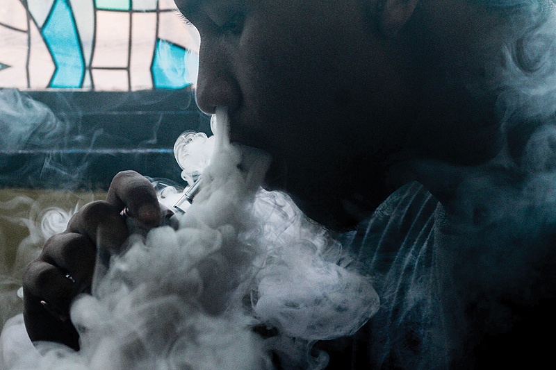 MANILA: A customer smokes at a vape store in the Philippine capital yesterday. - AFP