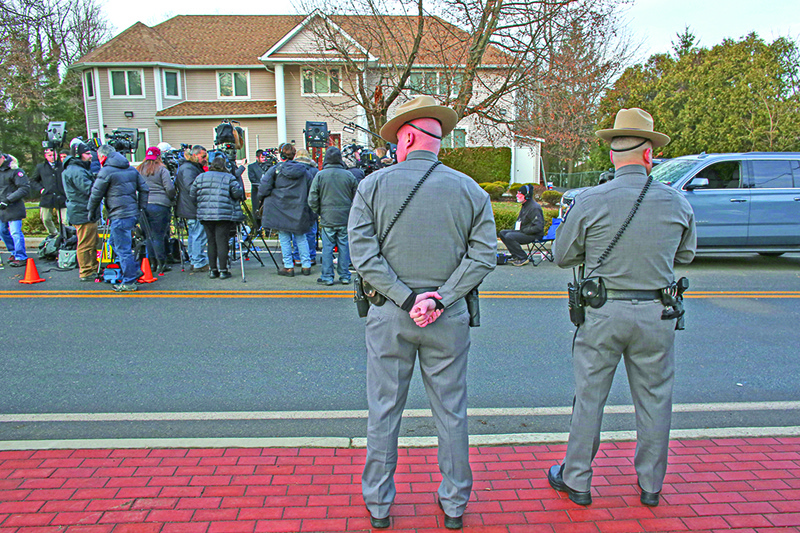 Two police officers stand guard as the press gathers outside a rabbi's home where a machete attack that took place earlier during the Jewish festival of Hanukkah, in Monsey, New York, on December 29, 2019. - An intruder stabbed and wounded five people at a rabbi's house in New York during a gathering to celebrate the Jewish festival of Hanukkah late on December 28, 2019, officials and media reports said. Local police departments, speaking to AFP, declined to give the number of people injured, but a suspect has been taken into custody and a vehicle safeguarded, an NYPD spokesman said. (Photo by Kena Betancur / AFP)