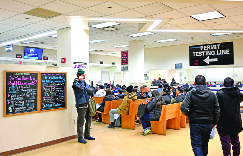 People wait at the New York State Department of Motor Vehicles (DMV) office at Atlantic Center in the Brooklyn borough of New York on December 18, 2019. - A new state law, the 'Green Light Law', allows New Yorkers age 16 and older to apply for a standard, not for federal purpose, non-commercial driver license or learner permit regardless of their citizenship or lawful status in the United States. (Photo by Angela Weiss / AFP)