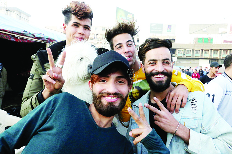TOPSHOT - Iraqi anti-government demonstrators sporting a pompadour hairstyle pose at Tahrir Square in central Baghdad on December 23, 2019. - Since the start of Iraq's anti-government protests on October 1, one thing strikes the eye perhaps above all else -- the unbridled hairstyles young men sport. High quiffs, tight fades and loads of attitude -- it is quite the male beauty pageant. (Photo by SABAH ARAR / AFP)