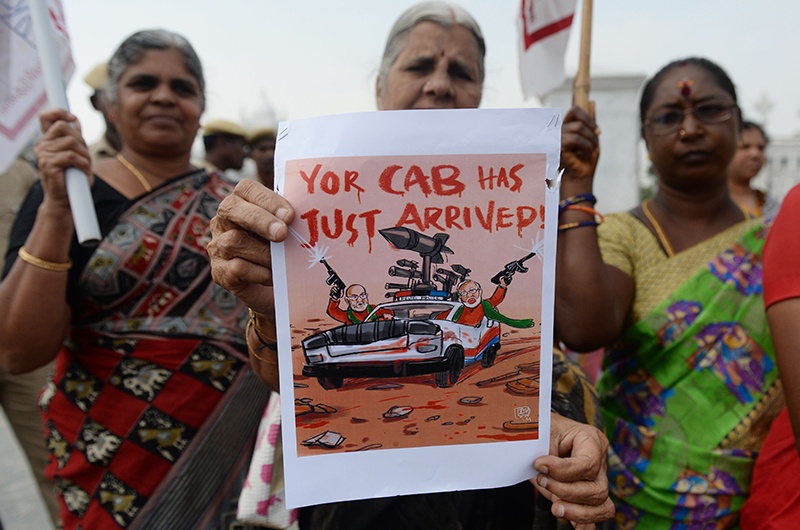 TOPSHOT - A woman holds a sign during a protest against India's new citizenship law Chennai on December 21, 2019. - An eight-year-old boy and four protesters were killed in India on Friday in clashes between police and demonstrators, officials said on December 21, as unrest over a controversial citizenship law rages into a second week. (Photo by Arun SANKAR / AFP)