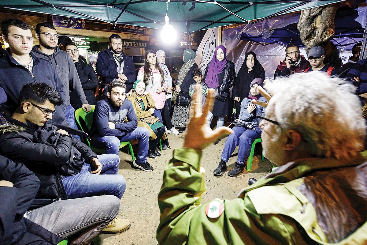 TRIPOLI: People gather at a tent where Lebanese anti-government protesters debate and discuss political and economic topics as part of an ongoing awareness at Al-Nour Square in this northern port city on Nov 27, 2019. — AFP