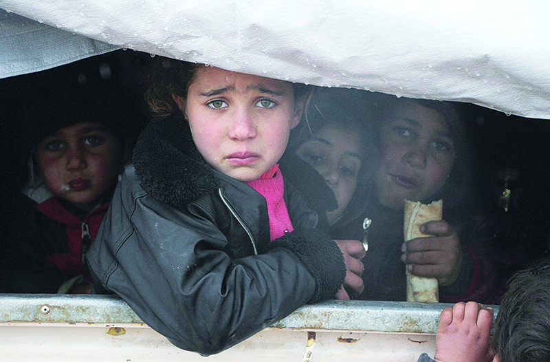 A Syrian child reacts upon her arrival in the back of a truck at a camp for displaced people near the village of Harbnoush in the Idlib province after fleeing government forces' advance on Maaret al-Numan in the south of the prvoince, on December 27, 2019. - Since mid-December, regime forces and their Russian allies have heightened bombardment on the southern edge of the final major opposition-held pocket of Syria, eight years into the country's devastating war. (Photo by Aref TAMMAWI / AFP)