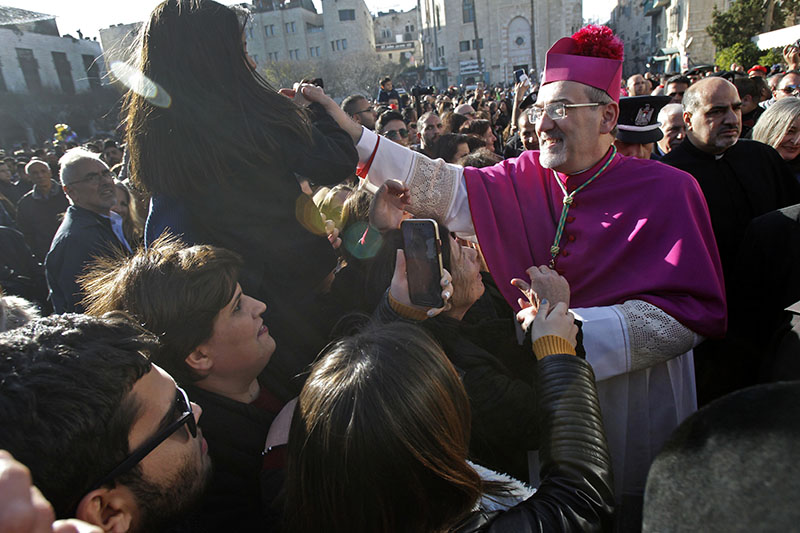 Pierbattista Pizzaballa, apostolic administrator of the Latin Patriarchate of Jerusalem, blesses worshippers ahead of Christmas Eve mass at the Church of the Nativity in the biblical West Bank city of Bethlehem on December 24, 2019. (Photo by Musa AL SHAER / AFP)