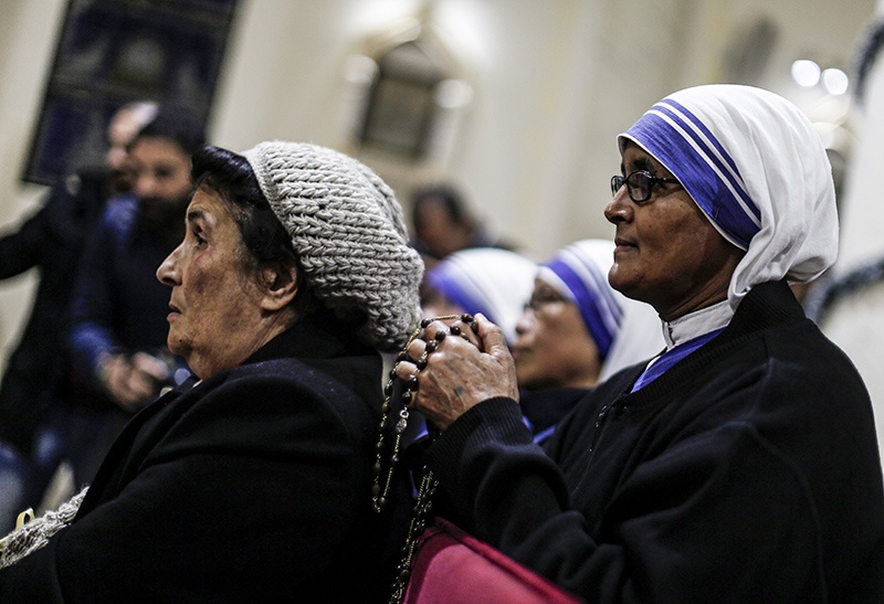 A Catholic nun of the Missionaries of Charity order holds a rosary as she attends Christmas Eve mass at the Roman Catholic Church of the Holy Family in Gaza City on December 24, 2019. (Photo by MAHMUD HAMS / AFP)