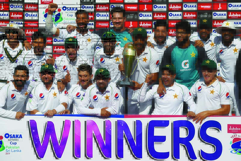 Pakistan's cricketers pose for a photograph with their trophy after winning the second Test cricket match between Pakistan and Sri Lanka at the National Cricket Stadium in Karachi on December 23, 2019. (Photo by Asif HASSAN / AFP)