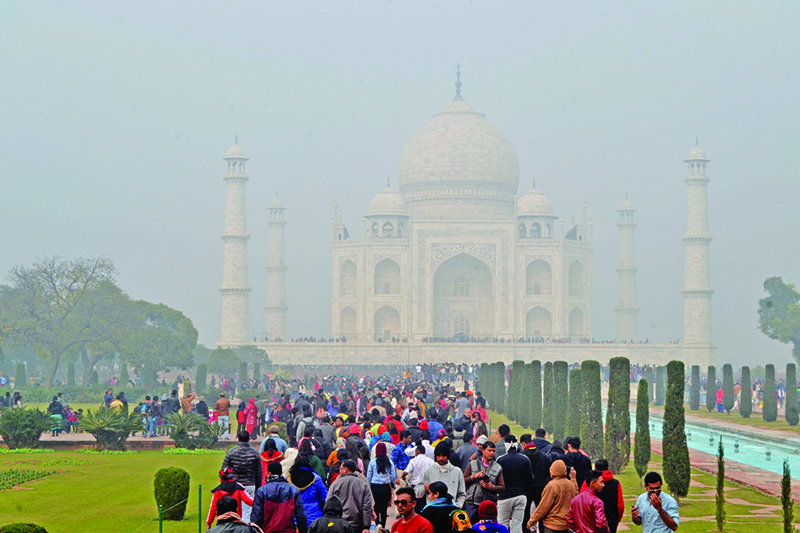 Tourists visit The Taj Mahal under heavy smog conditions in Agra on December 28, 2019. (Photo by STR / AFP)