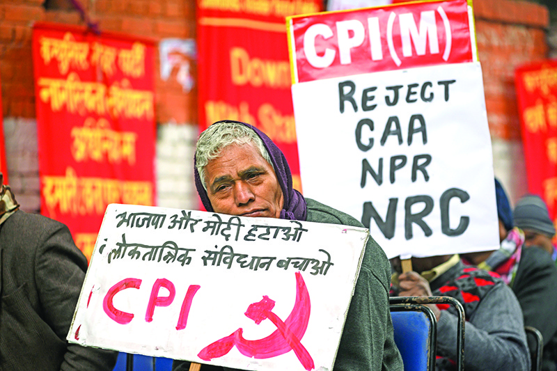 An activist of the Communist Party of India (CPI) holds a placard during a demonstration against India's new citizenship law in New Delhi on December 30, 2019. (Photo by Xavier GALIANA / AFP)