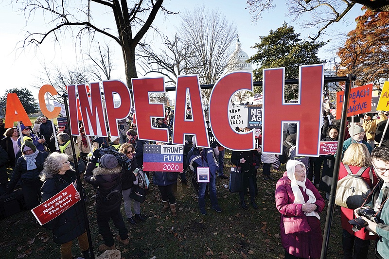 WASHINGTON: Protesters supporting the impeachment of US President Donald Trump gather outside the US Capitol yesterday. - AFP 