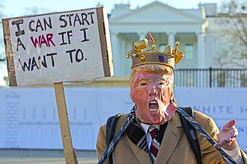 WASHINGTON, DC - JANUARY 08: A protestor wearing a stylized mask of President Donald Trump holds up a sign outside of the White House on January 8, 2020 in Washington, DC. Protesters have gathered to speak out against escalation towards Iran following the country's launch of more than a dozen ballistic missiles against two U.S.military bases in Iraq.   Samuel Corum/Getty Images/AFP