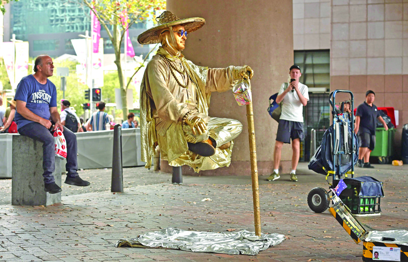 A busker performs for onlookers as people come out to celebrate Australia Day in Sydney on January 26, 2020. (Photo by PETER PARKS / AFP)