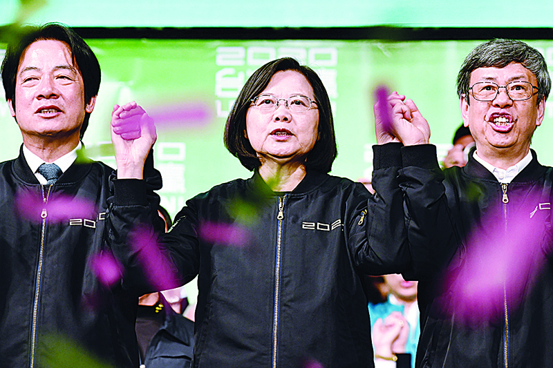 Taiwan President Tsai Ing-wen (C) joins her hands with Vice President-elect William Lai (L) and Vice President Chen Chien-jen outside the campaign headquarters in Taipei on January 11, 2020. - President Tsai Ing-wen declared victory in Taiwan's election on January 11 as votes were being counted after an election battle dominated by the democratic island's fraught relationship with China. (Photo by Sam Yeh / AFP)