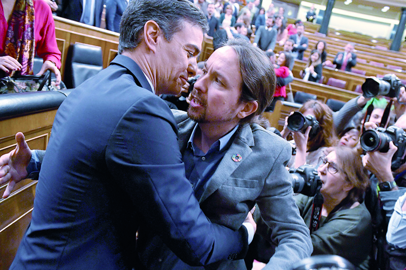 Spanish caretaker prime minister, socialist Pedro Sanchez, is congratulated by Spanish far-left Unidas Podemos coalition leader, Pablo Iglesias (R), after winning a parliamentary vote to elect a premier at the Spanish Congress (Las Cortes) in Madrid on January 7, 2020. - Spain's parliament today confirmed Socialist leader Pedro Sanchez by a razor-thin margin as prime minister for another term at the helm of the country's first-ever coalition government since its return to democracy in the 1970s. Sanchez, who has stayed on as a caretaker premier since inconclusive elections last year, got 167 votes in favour in the 350-seat assembly comapred to 165 against, with 18 abstentions from Catalan and Basque separatist lawmakers. (Photo by PIERRE-PHILIPPE MARCOU / AFP)