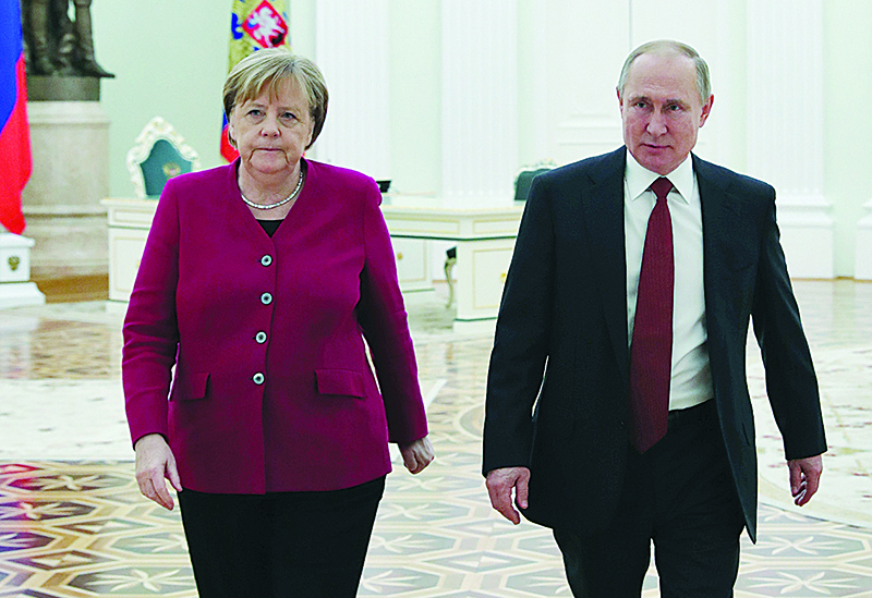 Russian President Vladimir Putin (R) and German Chancellor Angela Merkel leave a hall after a meeting at the Kremlin in Moscow, on January 11, 2020. (Photo by Mikhael Klimentyev / SPUTNIK / AFP)