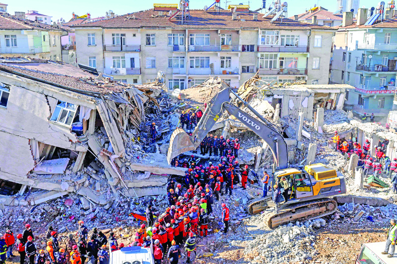 TOPSHOT - Rescue workers remove corpses from the rubble of a building after an earthquake in Elazig, eastern Turkey, on January 26, 2020. - Rescue workers raced against time on January 25 to find survivors under the rubble after a powerful earthquake claimed 22 lives and left more than 1,200 injured in eastern Turkey. The magnitude 6.8 quake struck in the evening of January 24, with its epicentre in the small lakeside town of Sivrice in Elazig province, and was felt across neighbouring countries. (Photo by BULENT KILIC / AFP)