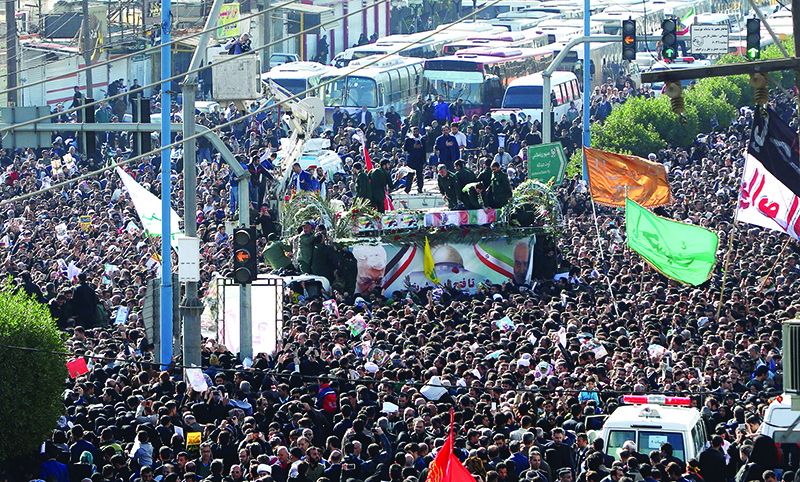 TOPSHOT - A large crowd surrounds the coffins of slain top commander Qasem Soleimani and Iraqi paramilitary chief Abu Mahdi al-Muhandis, as they are transported atop a vehicle after their arrival at Ahvaz International Airport in southwestern Iran on January 5, 2020. - A tide of mourners packed the streets of the Iranian city of Ahvaz today to pay respects to top general Qasem Soleimani, days after he was killed in a US strike. (Photo by FATEMEH RAHIMAVIAN / fars news / AFP)