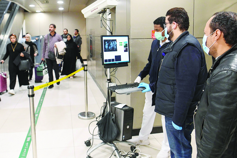 Temperature scanners are used to screen passengers for fever with upon their arrival at Kuwait international airport in Kuwait City on January 29, 2020. - The disease has spread to more than 15 countries since it emerged out of Wuhan late last year, with the death toll soaring to 132 and confirmed infections nearing 6,000.All confirmed fatalities have so far been in China. Cases have been reported across the Asia Pacific region and in North America and Europe, but the Wuhan family in the UAE are the first in the Middle East. (Photo by STR / AFP)