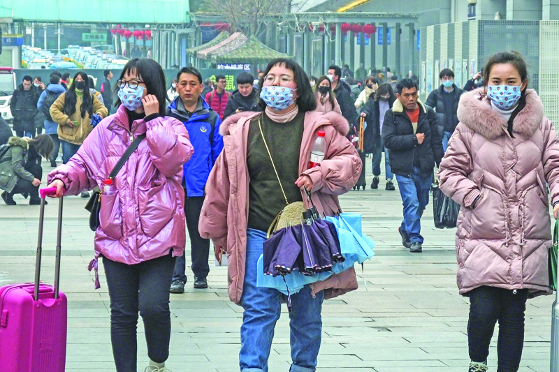 This photo taken on January 21, 2020 shows commuters wearing face masks arriving the Yichang East Railway Station, in China's central Hubei province. - The Chinese city at the centre of a SARS-like virus outbreak has urged people to stay away, cancelling a major Lunar New Year event, as it strives to contain a disease that has spread across the country. (Photo by STR / AFP) / China OUT