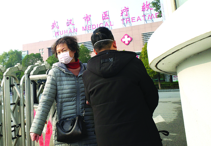 A woman (L) leaves the Wuhan Medical Treatment Centre, where a man who died from a respiratory illness was confined, in the city of Wuhan, Hubei province, on January 12, 2020. - A 61-year-old man has become the first person to die in China from a respiratory illness believed caused by a new virus from the same family as SARS, which claimed hundreds of lives more than a decade ago, authorities said. (Photo by Noel Celis / AFP)