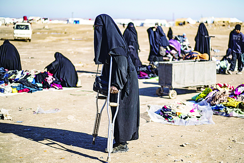 TOPSHOT - A French woman named Amal ,25, uses crutches to walk at the Kurdish-run al-Hol camp for the displaced in the al-Hasakeh governorate in northeastern Syria on January 14, 2020. - In the overcrowded Al-Hol desert camp for families linked to the Islamic State group in northeastern Syria, a French woman begs for another chance so she and her children can go home, while two others are more tepid about the prospect of repatriation, with one saying she fears being separated from her child. (Photo by DELIL SOULEIMAN / AFP)