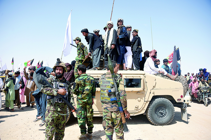 (FILES) In this file photo taken on June 17, 2018, Afghan Taliban militants and residents stand on a armoured Humvee vehicle of the Afghan National Army (ANA) as they celebrate a ceasefire on the third day of Eid in Maiwand district of Kandahar province. - The Taliban have offered a brief ceasefire to their US counterparts in Doha, two insurgent sources said on January 16, a move which could allow the resumption of talks seeking a deal for Washington to withdraw troops from Afghanistan. (Photo by JAVED TANVEER / AFP)