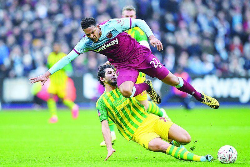 West Ham United's French striker Sebastien Haller (C) is tackled by West Bromwich Albion's Egyptian defender Ahmed Hegazy during the English FA Cup fourth round football match between West Ham United and West Bromwich Albion at The London Stadium, in east London on January 25, 2020. (Photo by JUSTIN TALLIS / AFP) / RESTRICTED TO EDITORIAL USE. No use with unauthorized audio, video, data, fixture lists, club/league logos or 'live' services. Online in-match use limited to 120 images. An additional 40 images may be used in extra time. No video emulation. Social media in-match use limited to 120 images. An additional 40 images may be used in extra time. No use in betting publications, games or single club/league/player publications. /
