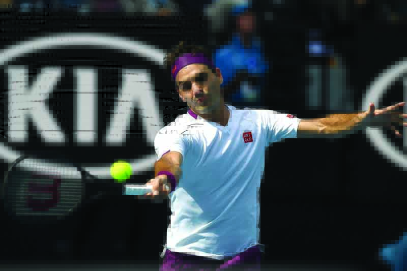 Switzerland's Roger Federer hits a return against Tennys Sandgren of the US during their men's singles quater-final match on day nine of the Australian Open tennis tournament in Melbourne on January 28, 2020. (Photo by Greg Wood / AFP) / IMAGE RESTRICTED TO EDITORIAL USE - STRICTLY NO COMMERCIAL USE