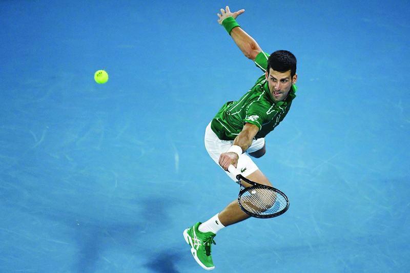 TOPSHOT - Serbia's Novak Djokovic hits a return against Switzerland's Roger Federer during their men's singles semi-final match on day eleven of the Australian Open tennis tournament in Melbourne on January 30, 2020. (Photo by Saeed KHAN / AFP) / IMAGE RESTRICTED TO EDITORIAL USE - STRICTLY NO COMMERCIAL USE