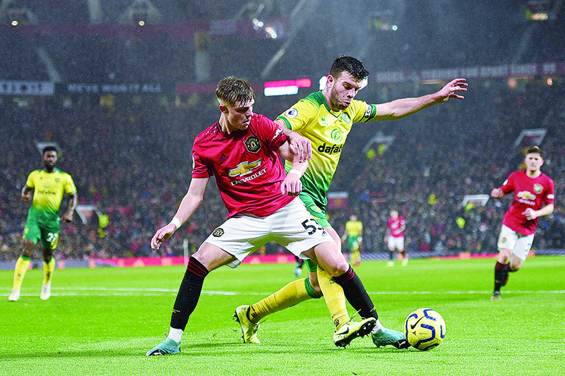 Norwich City's Scottish defender Grant Hanley (R) challenges Manchester United's English defender Brandon Williams (L) during the English Premier League football match between Manchester United and Norwich City at Old Trafford in Manchester, north west England, on January 11, 2020. (Photo by Oli SCARFF / AFP) / RESTRICTED TO EDITORIAL USE. No use with unauthorized audio, video, data, fixture lists, club/league logos or 'live' services. Online in-match use limited to 120 images. An additional 40 images may be used in extra time. No video emulation. Social media in-match use limited to 120 images. An additional 40 images may be used in extra time. No use in betting publications, games or single club/league/player publications. /