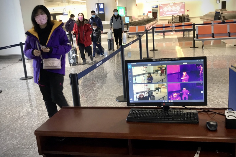 A thermal scanner screens arriving passengers for fever at Tianhe airport in Wuhan in China's central Hubei province on January 23, 2020. - China banned trains and planes from leaving a major city at the centre of a virus outbreak on January 23, seeking to seal off its 11 million people to contain the contagious disease that has claimed 17 lives, infected hundreds and spread to other countries. (Photo by Leo RAMIREZ / AFP)