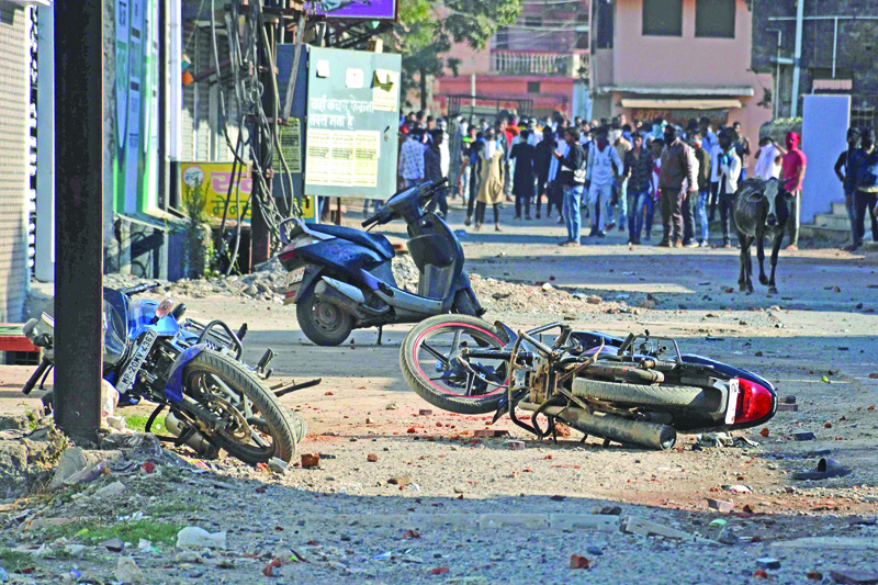 Damaged motorbikes are seen along a street scattered with stones after two communities clashed during a demonstration in support of the government's Citizenship Amendment Bill (CAB) in Adhartal town in Jabalpur district on January 26, 2020. (Photo by Uma Shankar MISHRA / AFP)