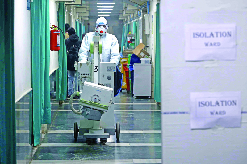 A medical staff member wearing protective clothing to help stop the spread of a deadly virus which began in Wuhan, works at an isolation ward in New Delhi on January 28, 2020, as 3 patients are under observation after returning from different part of China. - The epidemic, which experts believe emanated from a wild animal market in the city of Wuhan last month, has spread around China and to more than a dozen other countries despite the extraordinary travel curbs. (Photo by STR / AFP)