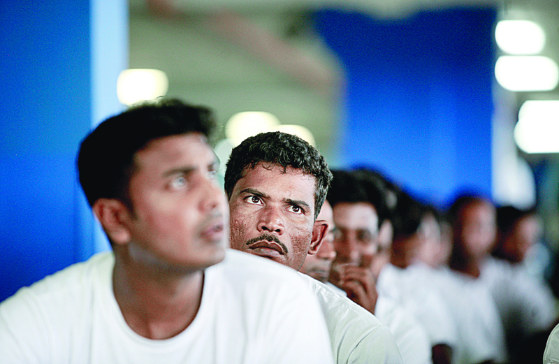 Foreign workers from Bangladesh wait at an airport carpark turned into an immigration depot in Sepang September 20, 2007. REUTERS/Bazuki Muhammad