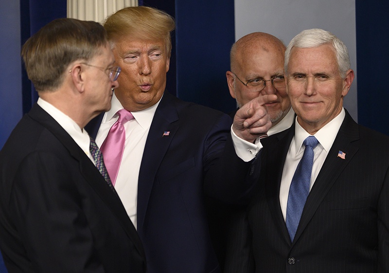 US President Donald Trump (2nd L) gestures, flanked by US Vice President Mike Pence (R), after speaking at a news conference on the COVID-19 outbreak at the White House on February 26, 2020. - US President Donald Trump on Wednesday defended his administration's response to the novel coronavirus, lashing the media for spreading panic as he conducts an evening news conference on the epidemic. (Photo by ANDREW CABALLERO-REYNOLDS / AFP)