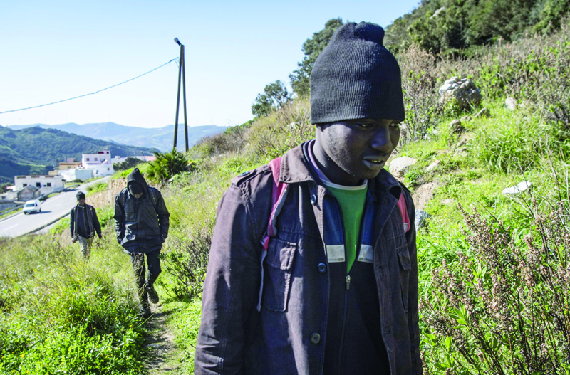 African migrants Mustapha (R), 18, and his travel companions Ahmed (C),17, and Omar, 17, wreturn to their hideout in the Belyounech forest, a few kilometres from Ceuta on Morocco's northern coast on January 16, 2020. - Today, migrants aiming to reach Europe from Morocco prefer to stay hidden, fearing the waves of arrests that have elicited condemnation from NGOs. nIn recent months, European pressure to shore up borders , bolstered by funding, has pushed Morocco to clamp down on migration. (Photo by FADEL SENNA / AFP)