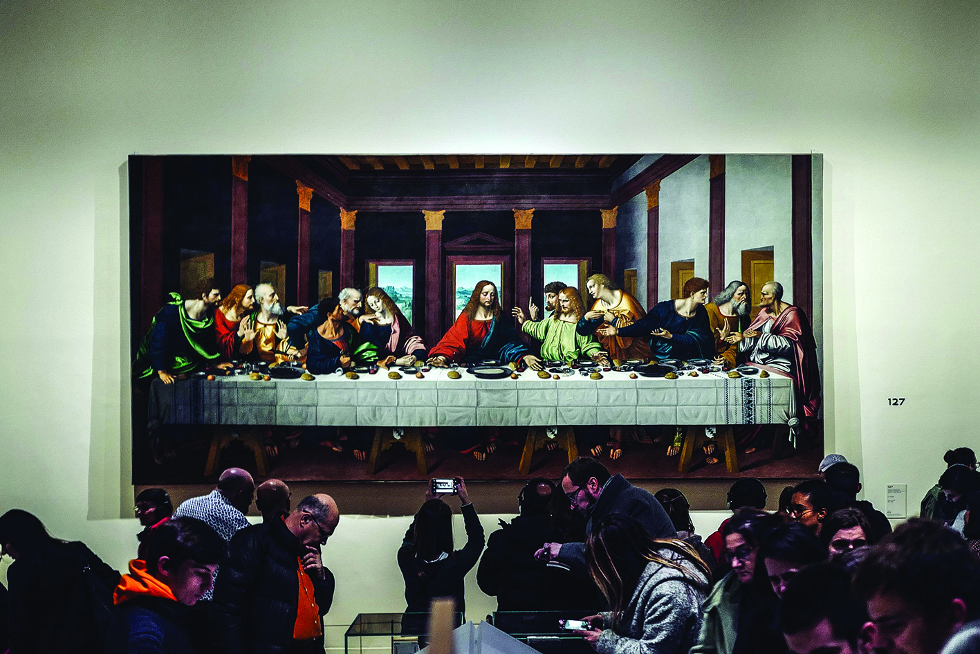 Visitors look at a version of 'The Last Supper' during the night and free opening of the 'Leonardo da Vinci' exhibition at The Louvre Museum on February 21, 2020 in Paris. - The Louvre announced that for its final days of opening on Friday February 21, Saturday 22 and Sunday 23, the exhibition would be open all night as well as for its regular daytime hours. (Photo by LUCAS BARIOULET / AFP)