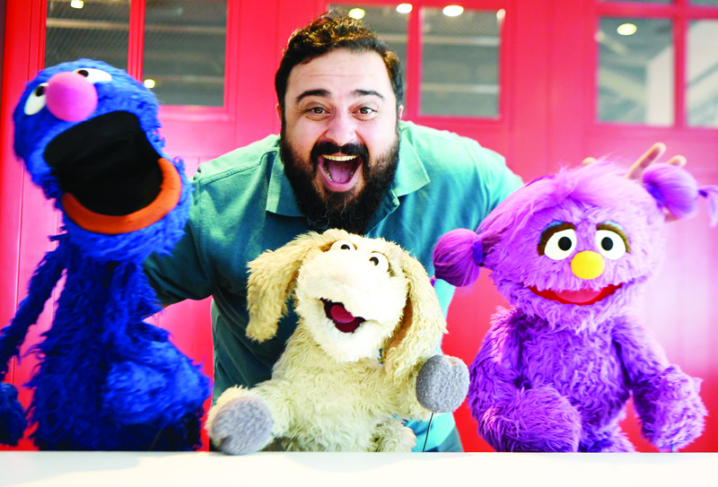 Hadi, the name of the character portrayed by a Jordanian actor Rami Delshad, poses for a picture with Grover (Gargur in Arabic) (L), Maízooza (C) and Basma (R) from the Sesame Street television series, in Dubai on January 28, 2020. - A band of Muppets, old favourites and new felt friends, will star in an Arabic retooling of Sesame Street six days a week on Middle East satellite channel MBC 3 from February 2, 2020.nWhile the long-running franchise addresses issues including family breakdown and LGBT relationships in its Western iterations, the new Middle East version will seek to help children, especially young Syrian refugees, cope with emotions. (Photo by KARIM SAHIB / AFP)