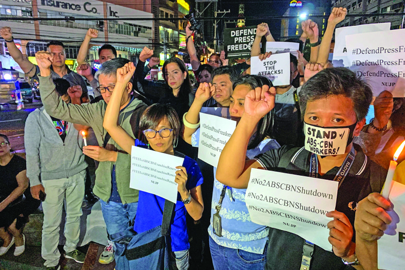 Staff and supporters raise their clinched fists during a protest in support of broadcaster ABS-CBN in Manila on February 10, 2020. - Philippine government lawyers moved on February 10 to strip the nation's biggest media group of its operating franchise in what campaigners branded a fresh attack on press freedom under President Rodrigo Duterte. (Photo by Ted ALJIBE / AFP)