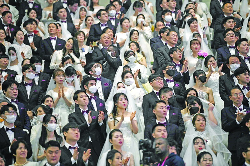 TOPSHOT - Couples wearing protective face masks attend a mass wedding ceremony organised by the Unification Church at Cheongshim Peace World Center in Gapyeong on February 7, 2020. - South Korea has confirmed 24 cases of the SARS-like virus so far and placed nearly 260 people in quarantine for detailed checks amid growing public alarm. (Photo by Jung Yeon-je / AFP)